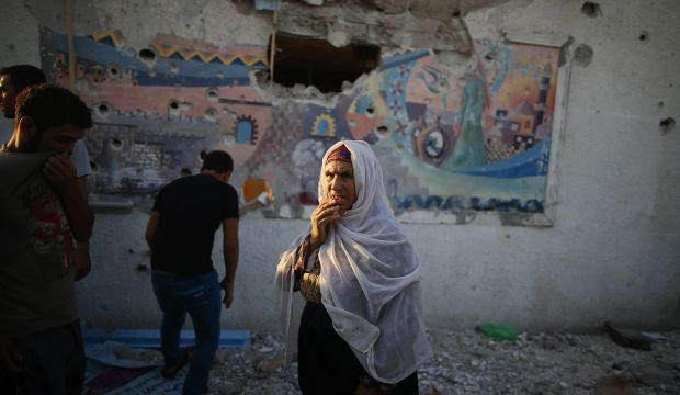 A Palestinian woman stands outside a United Nations-run school that witnesses said was hit by Israeli shelling in Jebalya refugee camp in the northern Gaza Strip on July 30, 2014. (Reuters/Mohammed Salem)