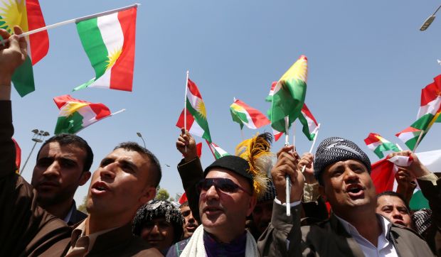 Iraqi Kurdish protesters wave the flag of their autonomous Kurdistan region during a demonstration for independence on July 3, 2014, outside the Kurdistan parliament building in Erbil</br>(AFP PHOTO/SAFIN HAMED)