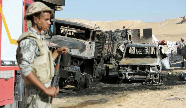 A picture made available on July 20, 2014 shows an Egyptian soldier guarding the site of an attack on a checkpoint which left 21 soldiers dead, 600 km south-west of Cairo towards the Libyan border. (EPA)