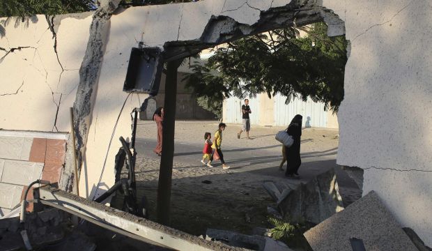 Palestinians are pictured through a damaged wall as they flee their houses following an Israeli ground offensive in Rafah on July 18, 2014. (Reuters/Ibraheem Abu Mustafa)