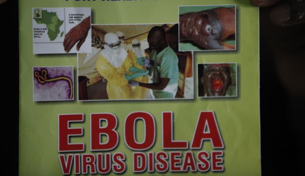 Nigeria health official display a leaflet explaining Ebola Virus Disease at the arrival hall of Murtala Muhammed International Airport in Lagos, Nigeria, Monday, Aug. 4, 2014. (AP Photo/Sunday Alamba)