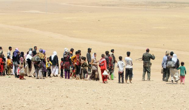 Displaced people from the minority Yazidi sect, fleeing violence from forces loyal to the Islamic State of Iraq and Syria in Sinjar town, make their way towards the Syrian border, on the outskirts of the Sinjar Mountains, near the Syrian border town of Elierbeh of Al-Hasakah Governorate, on August 10, 2014. (Reuters/Rodi Said)