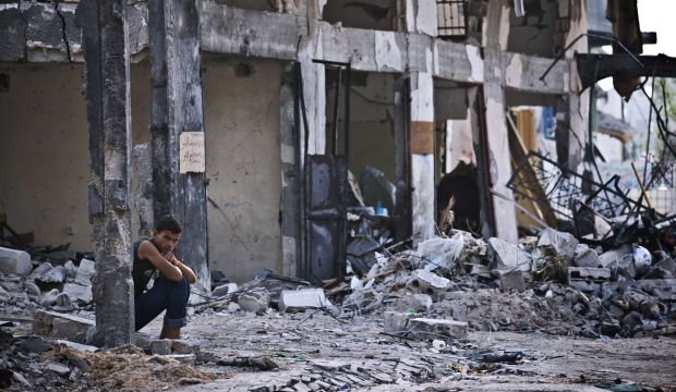 A Palestinian man sits amid the rubble of a destroyed building in Beit Hanoun in the northern Gaza Strip, on August 14, 2014. (AFP Photo/Roberto Schmidt)