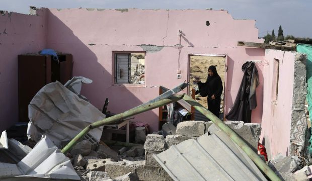 A Palestinian woman stands at the remains of her house which witnesses said was destroyed during the Israeli offensive in Johr El-Deek village near the central Gaza Strip August 17, 2014.(REUTERS/Ibraheem Abu Mustafa)