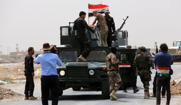 Members of the Iraqi anti-terrorism forces wave the national flag in celebration after securing a checkpoint from Sunni militants in the village of Badriyah, 10 miles west of Mosul on August 19, 2014. (AFP Photo/Ahmad Al-Rubaye)