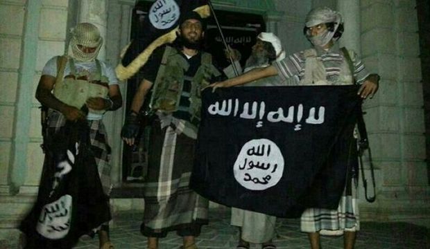 A picture taken with a mobile phone early on May 24, 2014 shows Al-Qaeda militants posing with Al-Qaeda flags in front of a museum in Seiyun, the second city in Hadhramaut province in Yemen. (AFP Photo/Stringer) 