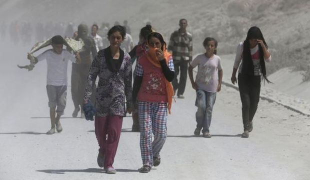 Displaced people from the minority Yazidi sect, who fled the violence in the Iraqi town of Sinjar, march in a demonstration at the Iraqi–Turkish border crossing in Zakho district of the Dahuk Governorate of the Iraqi Kurdistan province, on August 17, 2014. (Reuters/Youssef Boudlal)