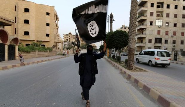 A member loyal to the Islamic State of Iraq and Syria (ISIS) waves an ISIS flag in the Syrian city of Raqqa, on June 29, 2014. (Reuters/Stringer)