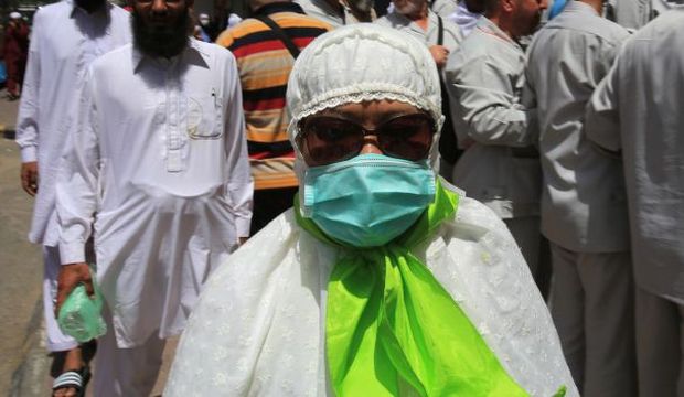 A Muslim pilgrim wears a surgical mask to help prevent infection from a respiratory virus known as the Middle East Respiratory Syndrome (MERS) in the holy city of Mecca, Saudi Arabia, on May, 13, 2014. (AP Photo/Hasan Jamali)