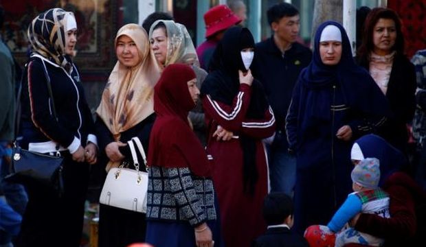 Uighur women stand next to a street to wait for a bus in downtown Urumqi, in the Xinjiang Uighur autonomous region in China, on May 1, 2014. (Reuters/Petar Kujundzic)