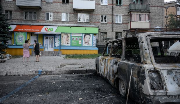 Locals observe the damage done to an apartment after shelling in the town of Donetsk, eastern Ukraine, on August 28, 2014.  (AP Photo/Mstislav Chernov)