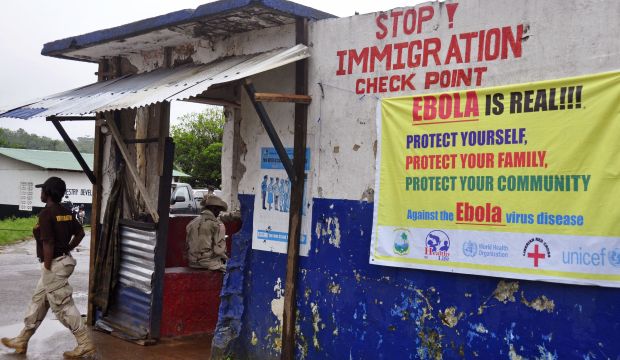 A Liberian soldier mans a checkpoint to control the movement of people as authorities try to prevent the Ebola virus from spreading on the outskirts of Monrovia, Liberia, on August 7, 2014. (AP Photo/Abbas Dulleh)