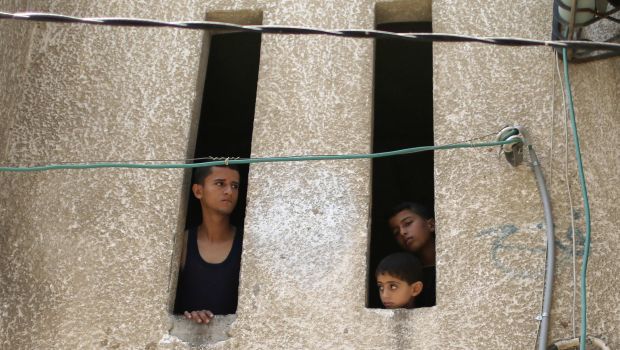 Palestinians watch the funeral of three children from the Al-Rifi family who medics said were killed in an Israeli airstrike, in Gaza City on August 21, 2014. (Reuters/Mohammed Salem)