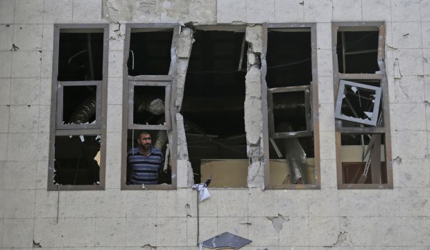 A guard at the Islamic University inspects the damage to the institution, which was hit in an overnight Israeli strike in Gaza City on August 2, 2014. (AP Photo/Lefteris Pitarakis)
