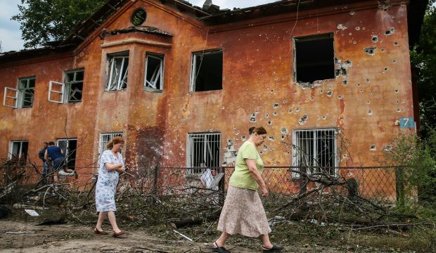 Residents walk past a damaged house after Ukrainian army shelling, in downtown Khartsyzk (15 miles from Donetsk), Ukraine, on August 18, 2014. (EPA/Sergei Ilnitsky)