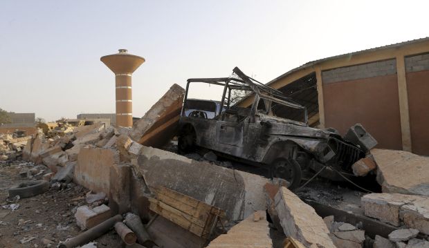 A burned car sits among rubble after fighting between Libyan special forces and ex-rebel fighters of the Benghazi Shura Council in the eastern city of Benghazi on July 30, 2014. (Reuters/Stringer )