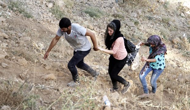 Yazidi refugees climb up a mountain-side as they flee from Iraq near Sirnak city, at the Turkish-Iraqi border, on August 17, 2014. (EPA/Ulas Yunus Tosun)