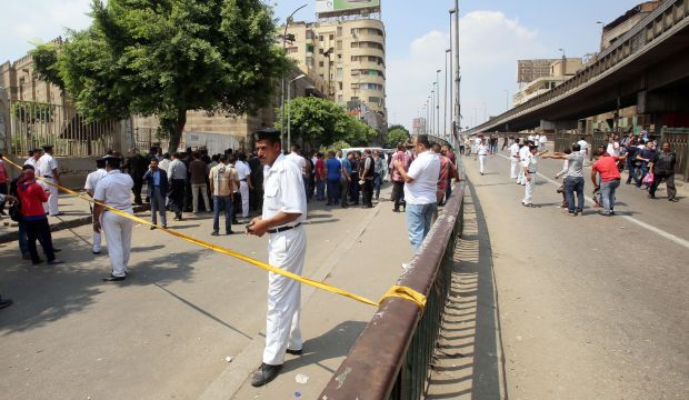 Egyptian security forces and forensic experts work at the site of a bomb attack near a checkpoint outside the foreign ministry headquarters in central Cairo on September 21, 2014. (AFP PHOTO / MOHAMED EL-SHAHED)