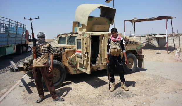 Islamic State of Iraq and Syria (ISIS) militants with a captured Iraqi Army Humvee at a checkpoint outside the Baiji oil refinery, 155 miles (250 kilometers) north of Baghdad, Iraq, in June, 2014 (AP Photo)