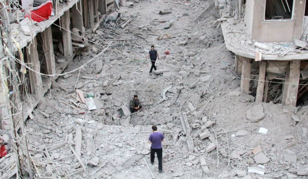 People walk on the rubble of damaged buildings after Syrian military helicopters allegedly dropped barrel bombs over the city of Daraya, southwest of the capital Damascus. (AFP Photo/Fadi Dirani)