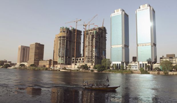 A boat passes buildings under construction and the two towers of the National Bank of Egypt building (R), overlooking the River Nile in Cairo, Egypt, on June 7, 2013. (Reuters/Asmaa Waguih)