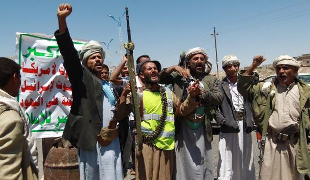 Armed Yemeni Shi’ite Houthi anti-government rebels shout slogans as they man a checkpoint erected after the Houthi group seized northern districts of the Yemeni capital Sana’a on September 21, 2014. (AFP Photo/Mohammed Huwais)
