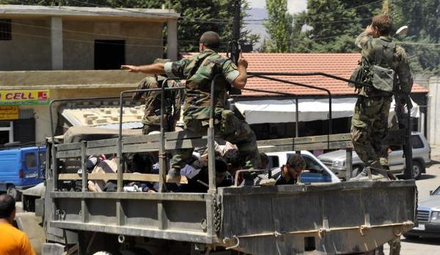 Lebanese army soldiers ride in a pick-up military vehicle with detained suspects from Arsal, in Labwe in the eastern Beqaa Valley, Lebanon, on August 6, 2014. (Reuters/Hassan Abdallah)