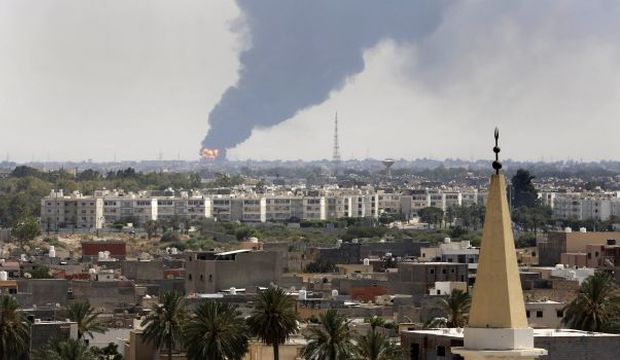 In this July 28, 2014 file photo, black smoke billows over the skyline as a fire at the oil depot at Tripoli airport rages out of control after being struck in the crossfire of warring militias battling for control of the airfield, in Tripoli, Libya. (AP Photo)