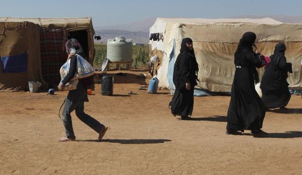 Syrian refugees walk inside an informal settlement in Deir Al-Ahmar, the Beqaa Valley, Lebanon, on September 16, 2014. (Reuters/Alia Haju)