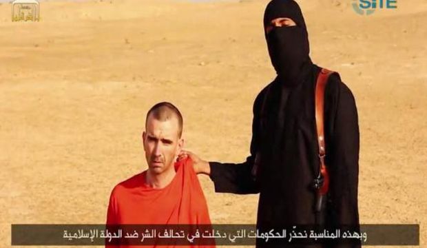 An image grab taken on September 2, 2014 from a video released by the Islamic State of Iraq and Syria (ISIS) and identified by private terrorism monitor SITE Intelligence Group purportedly shows footage of British aid worker David Cawthorne Haines being threatened by a masked militant in a desert landscape. (AFP Photo)