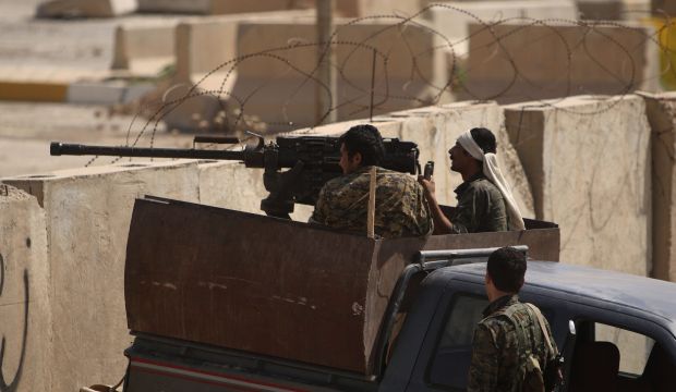 Members of the Kurdish People's Protection Units (YPG) man a weapon mounted on a pick-up truck as they take position behind cement blocks in the Iraqi city of Rabia on the Iraqi-Syrian border, in August 29, 2014. (REUTERS/Rodi Said)