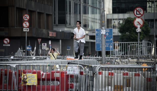 A cook walks between barricades of pro-democracy demonstrators in Hong Kong on October 6, 2014. (AFP PHOTO / Philippe Lopez)
