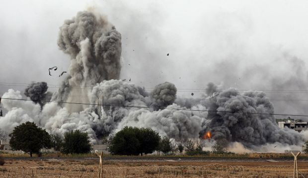 Thick smoke, debris and fire rise following an airstrike by the US-led coalition in Kobani, Syria as fighting intensified between Syrian Kurds and ISIS, as seen from Mursitpinar in the outskirts of Suruc, at the Turkey-Syria border, on Sunday, October 12, 2014. (AP Photo/Lefteris Pitarakis)