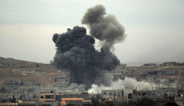 Thick smoke rises following an airstrike by the US-led coalition in Kobani, Syria on October 14, 2014 (AP Photo/Lefteris Pitarakis)