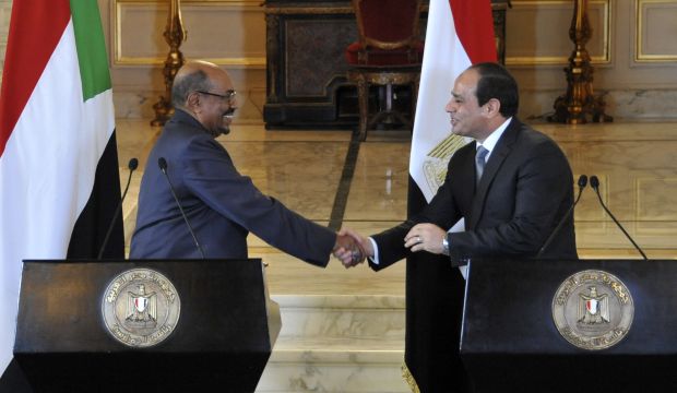 Sudan's President Omar Al-Bashir (L) and Egyptian President Abdel-Fattah El-Sisi (R) shake hands during a statement to the press at the end of Bashir's two-day visit, in Cairo, Egypt, on October 19, 2014. (AP Photo/MENA)