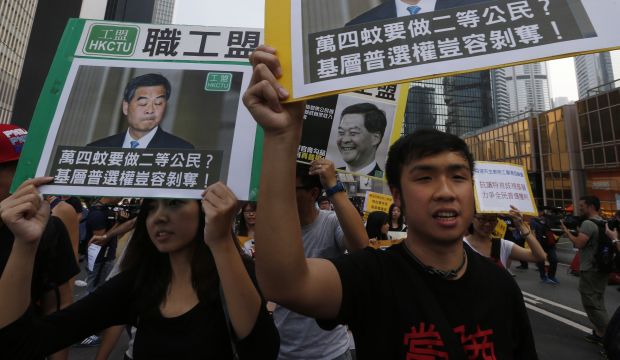 Pro-democracy protesters carrying portraits of Hong Kong Chief Executive Leung Chun-ying march to his residence in Hong Kong on October 22, 2014. (REUTERS/Bobby Yip)