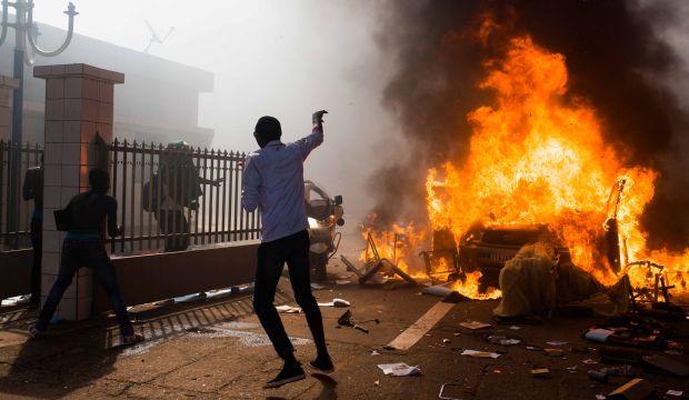 A car burns outside the parliament building in Burkina Faso as people protest against their longtime President Blaise Compaore who seeks another term in Ouagadougou, Burkina Faso, on October 30, 2014. (AP Photo/Theo Renaut)