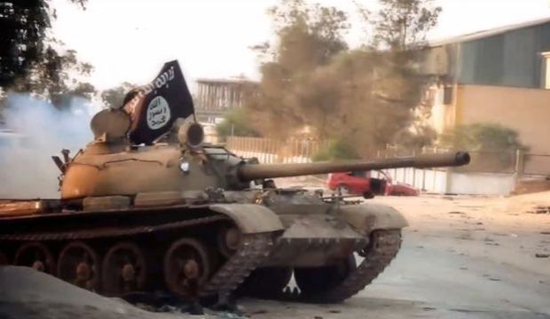 An image taken from a video made available on October 9, 2014, allegedly shows a tank, belonging to the Ansar Al-Shari'a militant group, flying the trademark jihadist flag during a battle in the Libyan city of Benghazi. (AFP Photo)