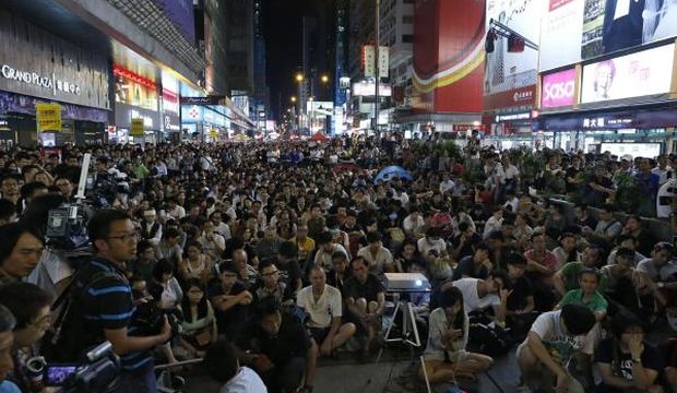 Pro-democracy protesters watch a broadcast of the negotiations between representatives of government and student protesters beamed on a screen during an Occupy Central demonstration in the Mong Kok District of Hong Kong, China, 21 October 2014. 