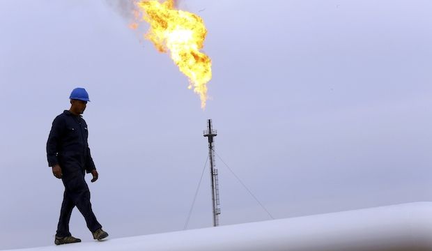 This file photo shows a worker walking on an oil pipeline at the Khurmala oil field on the outskirts of the city of Erbil, in Iraq's Kurdistan region, on December 4, 2013. (Reuters/Stringer)