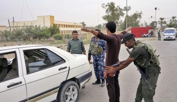 A member of the Iraqi security force searches a man at a checkpoint in Ramadi, on October 12, 2014. (Reuters/Stringer)