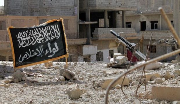 Opposition forces from the Al-Ikhlas Brigade fire a home-made rocket, next to an Islamist flag bearing the name of their brigade, in Syria's northeastern city of Deir Ezzor, on October 9, 2013. (AFP/Ahmad Aboud)