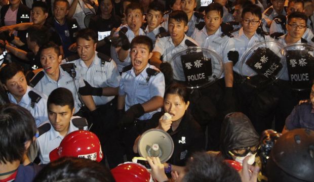 Police react as they disperse pro-democracy protesters on a main road near the government headquarters in Hong Kong on October 15, 2014. (Reuters/Apple Daily)