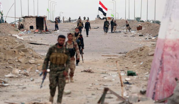 Iraqi pro-government forces walk in Jurf al-Sakhar, south of Baghdad, on October 27, 2014 after they retook the area from Islamic State of Iraq and Syria (ISIS) jihadists over the weekend after months of fighting. (AFP/Mohammed Sawaf)
