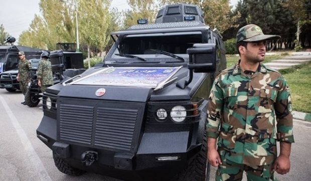 Iranian police man stands next to anti-riot vehicle. (Tasnim News Agency)