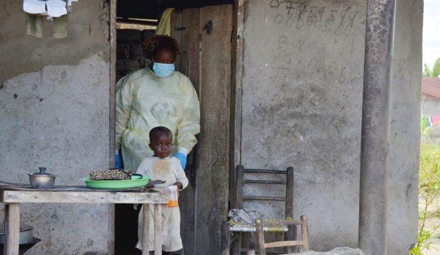 A member of the NGO U Fondation leaves a house after visiting quarantined family members suffering from the Ebola virus, on October 16, 2014, in Monrovia, Liberia. (AFP Photo/Zoom Dosso)