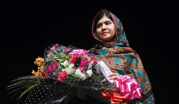 Malala Yousafzai with flowers from the Prime Minister of Pakistan during a press conference in Birmingham, Britain, on 10 October 2014. (EPA)