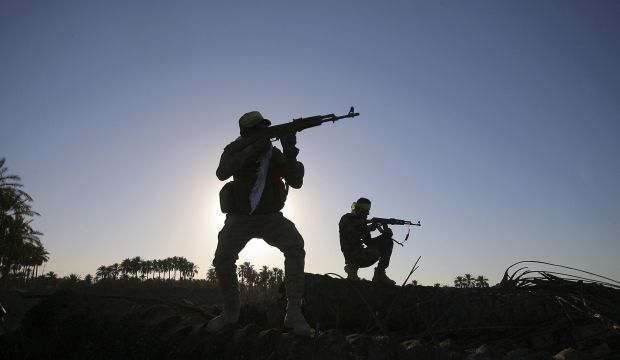 Iraqi Shi'ite militiamen aim their weapons during clashes with the Islamic State of Iraq and Syria (ISIS), in Jurf Al-Sakhar, about 43 miles (70 kilometers) southwest of Baghdad, Iraq, on October 7, 2014. (AP Photo)
