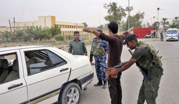 A member of the Iraqi security forces searches a man at a checkpoint in Ramadi, on October 12, 2014. (Reuters/Stringer)