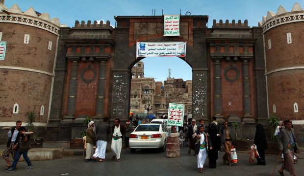 Yemenis walk through the main gate of the old city of Sana'a on October 10, 2014. (AFP Photo/Mohammed Huwais)